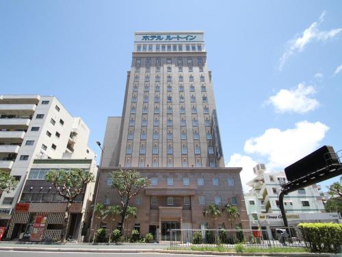 Un palazzo alto con un cartello sopra. di Hotel Route-Inn Nahatomariko a Naha