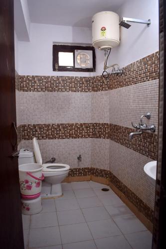 a bathroom with a toilet and a sink at Hotel Thakur Ji in Haridwār