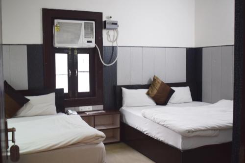 Hotel Thakur Ji tesisinde bir odada yatak veya yataklar