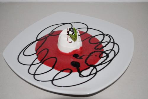 a white plate with a red dessert with whipped cream at pension N.10 in Frymburk