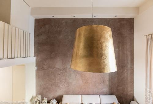 a large gold pendant hanging over a couch at Elena House Gold Apartment in Viareggio