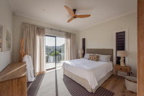 a bedroom with a bed and a large window at Moa 30 Runga - Waiheke Island in Oneroa