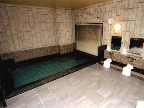 a room with a pool of water and two mirrors at Hotel Route-Inn Niigata Kencho-minami in Niigata
