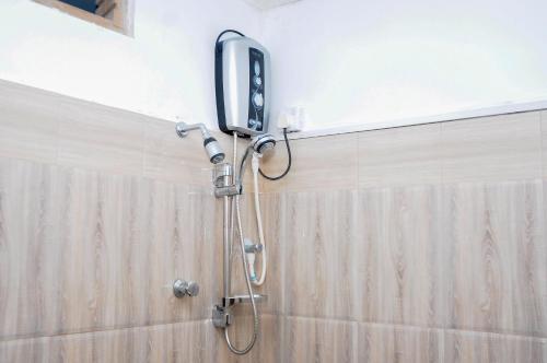 La salle de bains est pourvue d'une douche et d'un téléphone mural. dans l'établissement Restwell Homestay, à Dambulla
