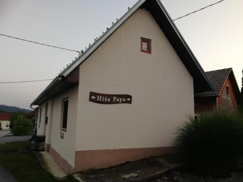 a white building with a sign on the side of it at Apartment House Papa in Vinica