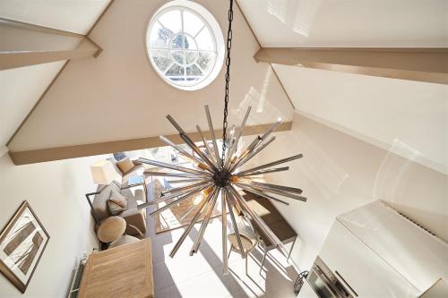 a large chandelier hangs from the ceiling of a staircase at Villa Magnolia in Oostkapelle