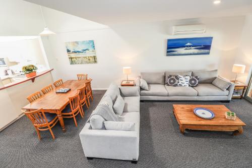 a living room with a couch and a table at Bayshore Beachside Resort in Dunsborough