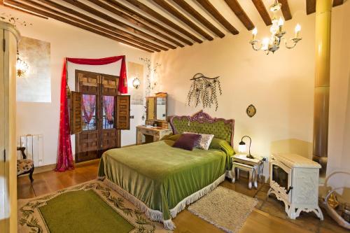Schlafzimmer mit einem Bett mit grüner Tagesdecke in der Unterkunft Casa Palacio Rincón de la Catedral in Toledo