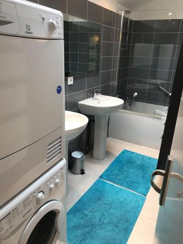 une salle de bain avec un lavabo et une machine à laver dans l'établissement Stella maris, à Neuville-lès-Dieppe