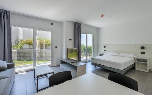 a bedroom with a bed and a living room at Apartamentos Onzamar in Sanxenxo