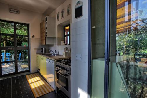 a kitchen with a stove top oven next to a window at Casali Marchigiani - Ville vacanza private con piscina in Ostra
