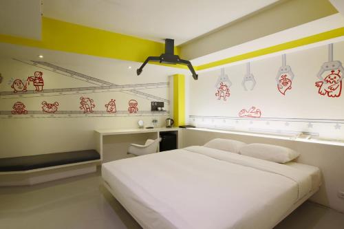 a bedroom with a white bed and red signs on the wall at Hotel Papa Whale-Kaohsiung Formosa Boulevard in Kaohsiung