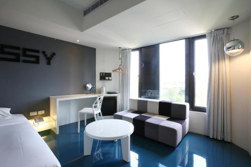 a hotel room with a bed and a couch and a table at Hotel Papa Whale-Kaohsiung Formosa Boulevard in Kaohsiung