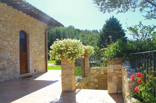 a stone fence with a gate with flowers on it at Antica Fonte in Assisi