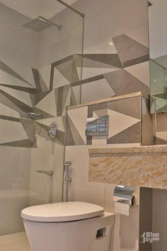 a bathroom with a toilet and a glass wall at The Blue Jay Hostel - Dorms & Rooms in Rishīkesh
