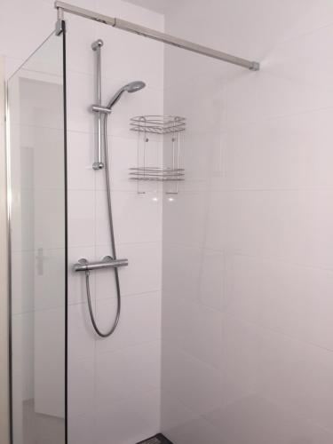 a shower with a glass door in a bathroom at Bnbrose in Amsterdam