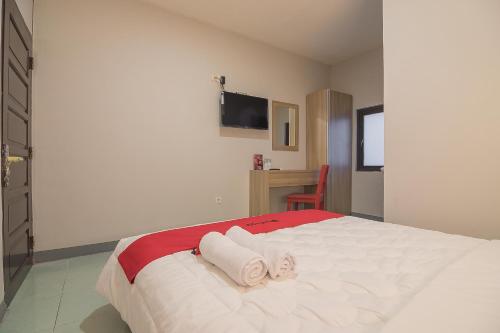 a bedroom with a bed with towels on it at RedDoorz @ Kiaracondong in Bandung
