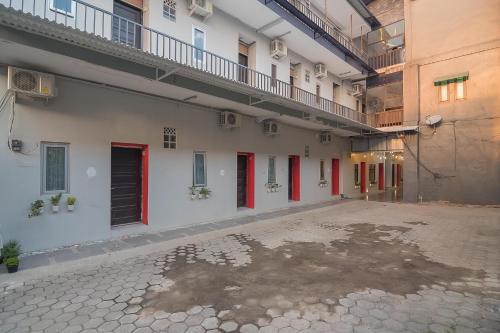 an empty courtyard of a building with red doors at RedDoorz @ Kiaracondong in Bandung