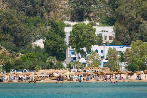 a beach with umbrellas and people on the water at Maison Dedine- SmallLuxuryHotels -Adults Only in Sidi Bou Saïd