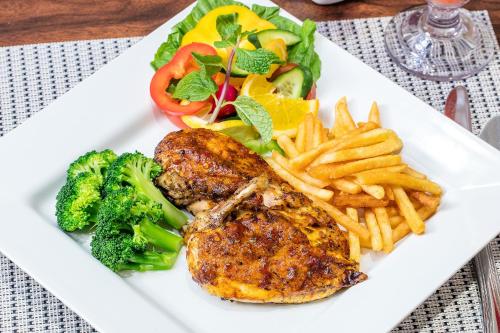 a plate of food with broccoli and french fries at Gulf Court Hotel in Manama