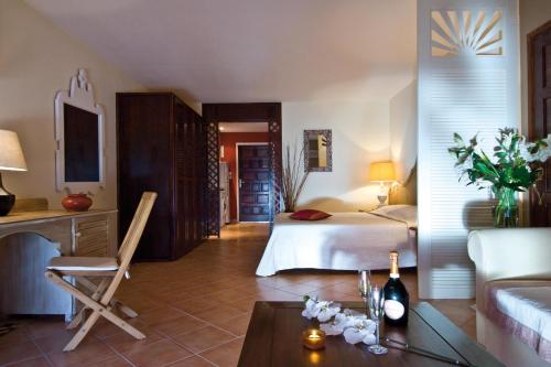 a bedroom with a bed and a table with a bottle of wine at Studio Orient Bay in Orient Bay
