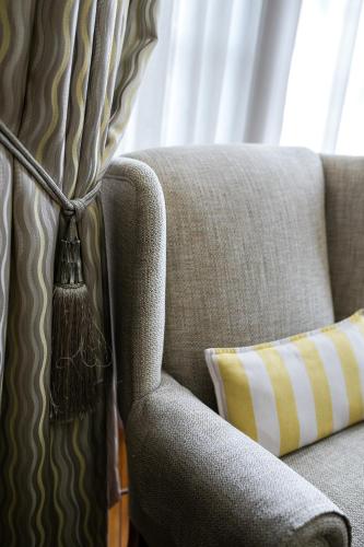 a couch with a pillow next to a window at Van Dykshuis Guest House in Heidelberg