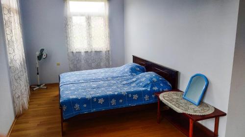 um quarto com uma cama, uma cadeira e uma janela em Guesthouse Green Oasis em Gonio