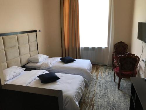 a hotel room with two beds and a window at Vanadzor Armenia Hotel in Vanadzor
