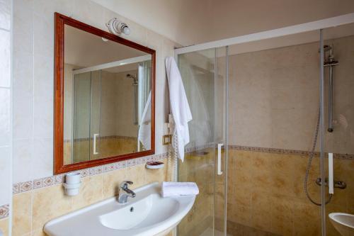 a bathroom with a sink and a shower and a mirror at La Vignazza B&B in Marzamemi