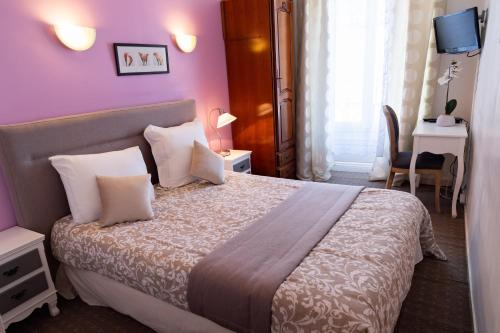 a bedroom with a large bed with purple walls at Hotel Henri IV in Sully-sur-Loire