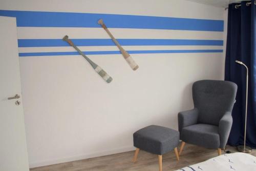 Zimmer mit einer Wand mit zwei Baseballschlägern und einem Stuhl in der Unterkunft Wohnung "Föhr" - Haus Dünengras in Büsum