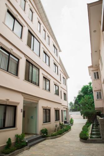 a large white building with a sidewalk in front of it at Sarovar Residency Serviced Apartment Hotel in Jawlakhel