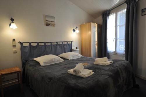 a bedroom with a bed with towels on it at Le Concept Hotel in Les Portes