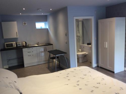um quarto com uma cama, um lavatório e uma casa de banho em Swans Nest em Holmfirth