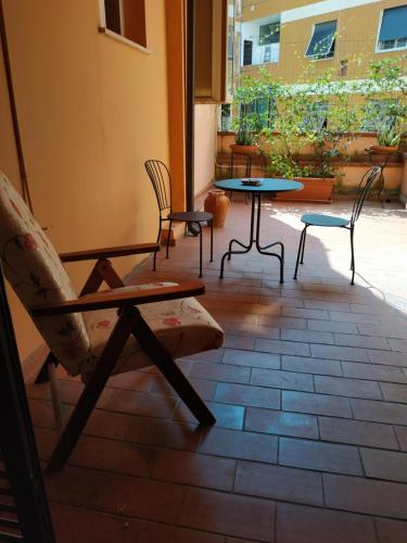 un patio con sillas, mesas y una ventana en Gemini camere e suites, en Grosseto