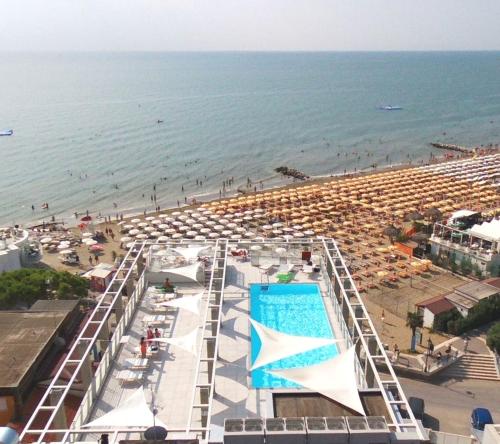 a view of a beach with umbrellas and a swimming pool at Hotel Marco Polo in Caorle