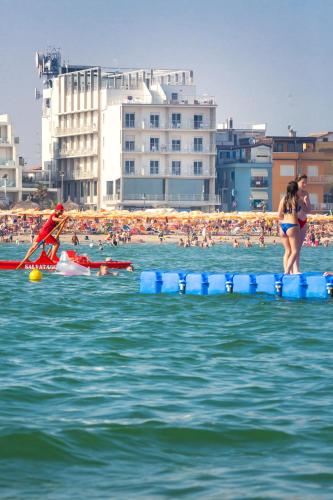 a group of people in the water at a beach at Hotel Marco Polo in Caorle
