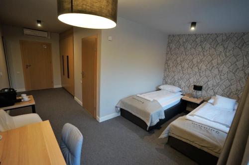 a hotel room with two beds and a table at Kamienica nr 6 in Aleksandrów Łódzki