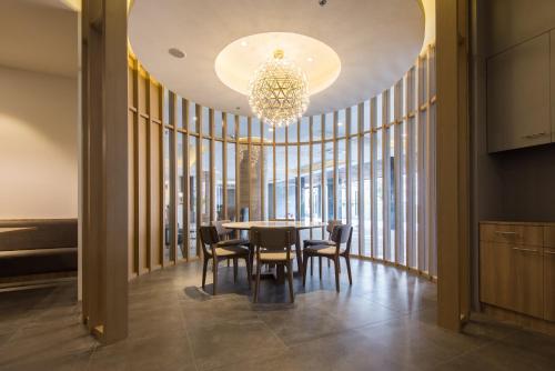 a dining room with a table and chairs and a chandelier at Madison Bangkok Hotel in Bangkok