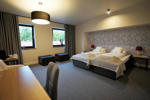 a hotel room with a large bed and a table at Kamienica nr 6 in Aleksandrów Łódzki