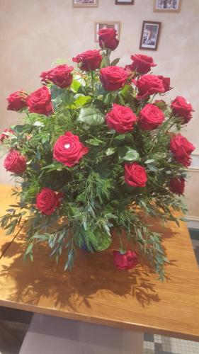 a bouquet of red roses sitting on a table at Le Cheval Rouge in Louhans