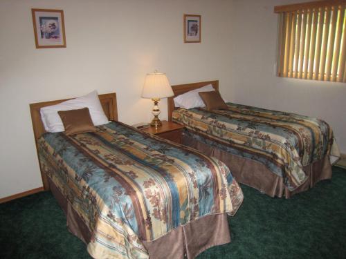 a hotel room with two beds and a lamp at Fairmont Villas Mountainside in Fairmont Hot Springs