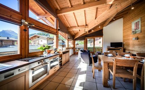 een keuken en eetkamer met een houten plafond bij Aiglon Morzine in Morzine