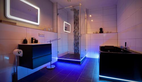 a bathroom with a bathtub, sink, and shower stall at K&M Hostel in Hamburg
