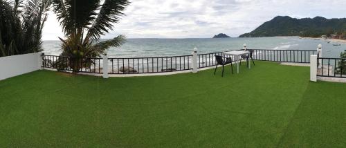 un balcón con césped junto al océano en Simple Life Cliff View Resort, en Ko Tao