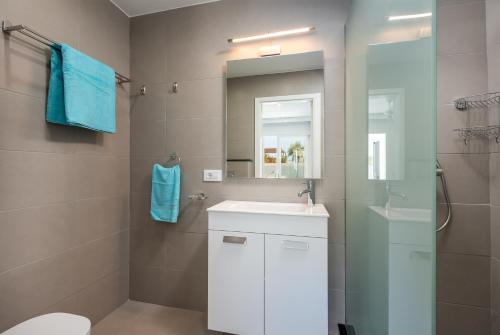 a bathroom with a white sink and a mirror at Luxurious 5* VILLA - 300M2 - private HEATED pool - garage - WiFi in Palm-mar
