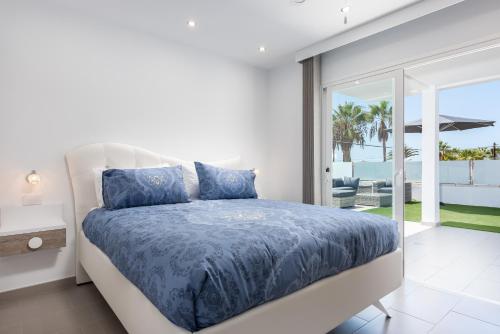a bedroom with a bed and a view of the ocean at Luxurious 5* VILLA - 300M2 - private HEATED pool - garage - WiFi in Palm-mar