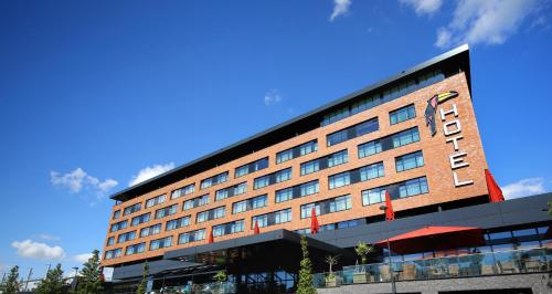 a hotel building with a blue sky in the background at Van der Valk Hotel Oostzaan - Amsterdam in Oostzaan