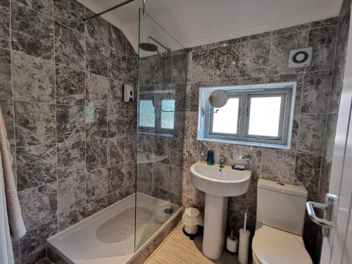 uma casa de banho com um lavatório, um WC e um chuveiro em The Mill Hotel em Stone