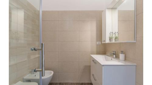 a bathroom with a sink and a toilet and a mirror at Villas Marisol in Premantura